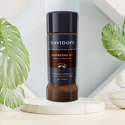 Davidoff Espresso 57 Intense coffee beans in a wooden spoon. A cup of strong and aromatic Davidoff Espresso 57 Intense.