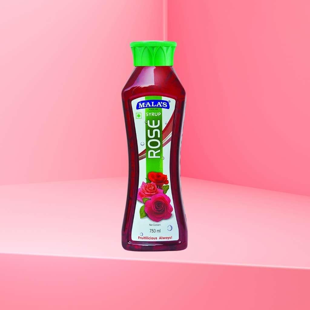 A bottle of Mala's Rose Syrup Rose petals floating in a glass of rose syrup
